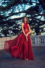 Fashionable hair disheveled braid around the head .Happy beautiful young model girl in summer blossom park.