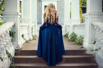 Fashionable hair disheveled braid around the head .Happy beautiful young model girl in summer blossom park.