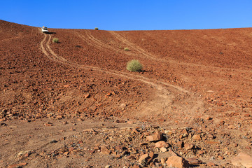 Geländewagen fährt steinigen Hügel hinunter, Damaraland, Kunene Region