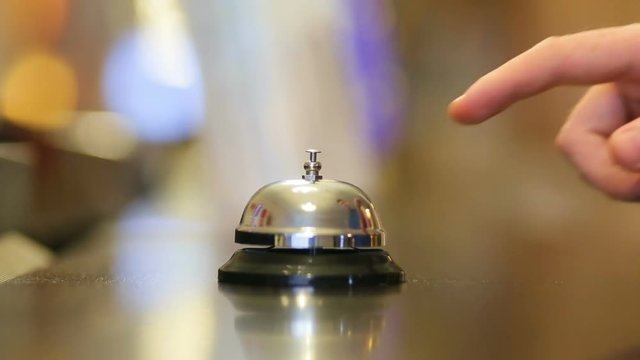 Hand of a man using a hotel bell