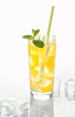 Glass of cold refreshing orange drink with ice and mint