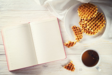 Cup of tea, waffle and notepad with space for text