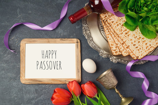 Passover holiday concept seder plate, matzoh and photo frame on dark background. Top view from above