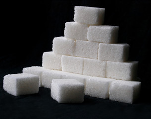 pile of sugar cubes over black background