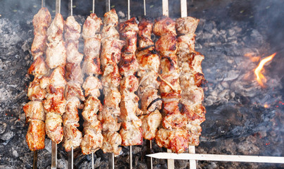 shish kebab on skewers on the grill with flames