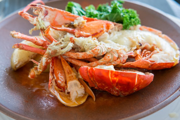 Lobster with garlic beurre noisette and  potatoes on plate.