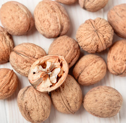 Walnut kernels and whole walnuts on wooden table