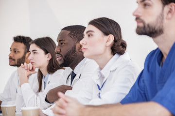 Fototapeta premium Careful physician hearing talk at conference in hospital room