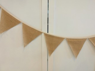 Fabric flag strips hanging left to right on the white folding door wall decorate for party at home