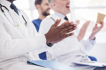 Physician applauding at conference in hospital