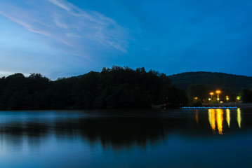 Fin de coucher de soleil au lac Chambon en France. Reflet lumineux sur l'eau des éclairages publics