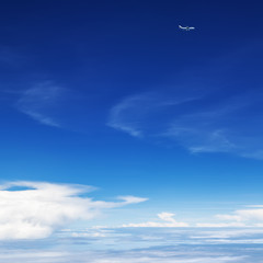 Oncoming flight traffic in mid air. Aircraft flying above earth, beautiful white cloud. Clear blue sky, aerial view from cabin through plane window. Vacation tour, travel background with copy space