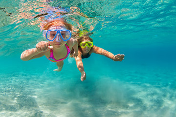 Happy family - mother with baby girl dive underwater with fun in sea pool. Healthy lifestyle,...