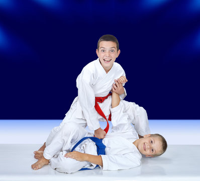 Two boys are trained judo throws