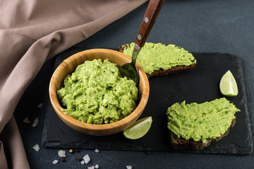  Guacamole pasta and avocado on dark background. Vegetarian  food