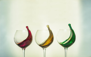 Three glasses with colorful drinks red, yellow, green