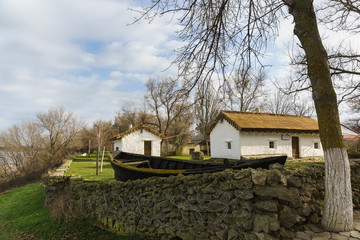 Old clay house, a thatched-roof boat and fence