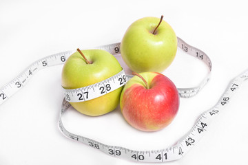 Measuring tape and apple on a white background isolation. Diet for weight loss which advise doctors nutritionists. Proper nutrition with vitamins.