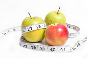 Measuring tape on which apple on an isolated background. Dietary food and proper nutrition for athletes. Tips nutritionists doctors.