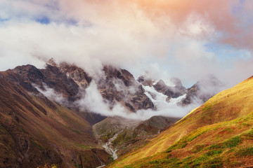 Autumn landscape and snowy mountain peaks.
