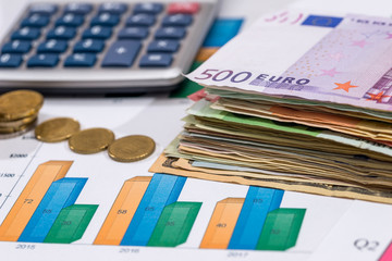 euro bills with calculator and pen on financial settlement with the charts.