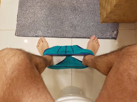 Up point of view of a man sitting in the toilet