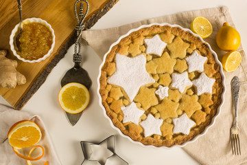 Flat lay tart with lemon and orange, ginger jam decorated with star-shaped cookies