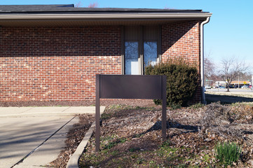Brown empty board for advertisement near the brick house