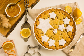 Flat lay tart with lemon and orange, ginger jam decorated with star-shaped cookies