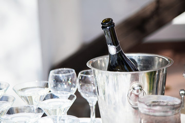 Bottle of chilled champagne, wineglasses are in ice bucket for g