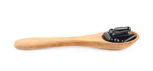 Spoon full of capsule pills isolated