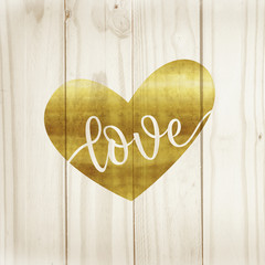 Corazón dorado sobre fondo de madera clara