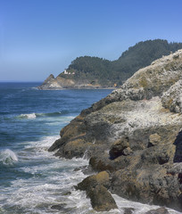 Fototapeta na wymiar Coastline landscape with a lighthouse off in the distance.