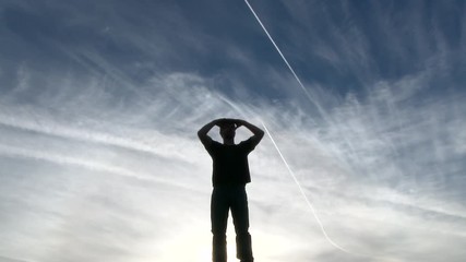 Model released, silhouette of man looking out, searching the vast sky.