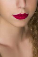 Fototapeta premium Close up of young woman beautiful lips with red lipstick.