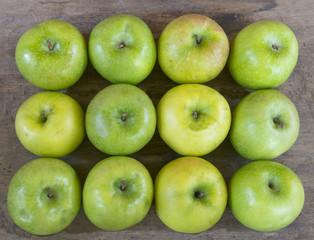 Large group of healthy, green apples on wooden table