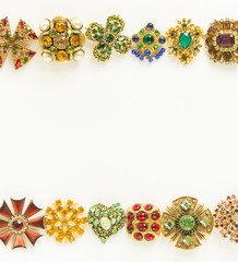 Woman's Jewellery. Frame with old vintage brooches. Beautiful bright rhinestones brooches on white....