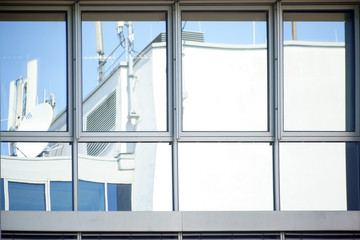 Kommunikationsequipment gespiegelt / Kommunikationsequipment wie Sendeantennen und Satellitenempfänger gespiegelt in Fenstern.