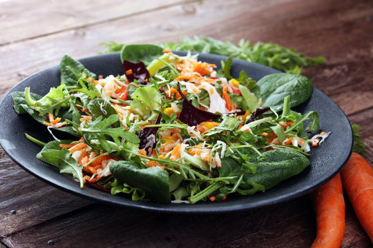 Fresh diet fitness salad of daikon radish, carrots, flax seeds, arugula. Vegan cuisine.