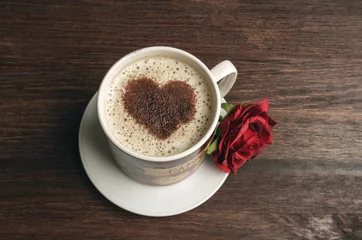 Fotobehang Coffee cup with heart shape and red rose on dark background © alexscr