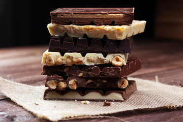 Chocolate bars on a wooden background with chocolate tower