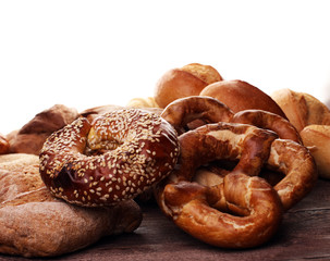 Different kinds of bread and bread rolls on board from above. Ki