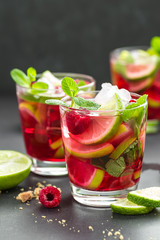 Raspberry mojito cocktail with lime, mint and ice, cold refreshing drink