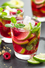 Raspberry mojito cocktail with lime, mint and ice, cold refreshing drink