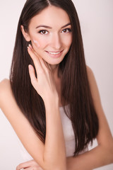 beauty, people, skincare and cosmetics concept - happy young woman with moisturizing cream on hand and facial