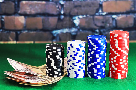 Casino chips and money on green poker table
