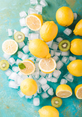 Lemons and ice on a turquoise background. Lemons. Fruits. Kiwi. Mint. Healthy food concept. Copyspace