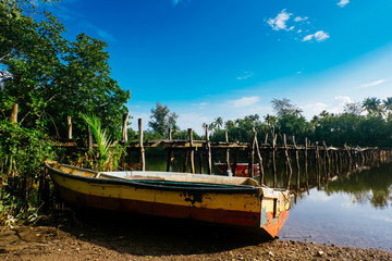 Fototapeta na wymiar beautiful nature with reflection, fiber boat and wooden bridge at sunny day