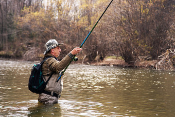 Fisherman standing in river when fishing for grayling