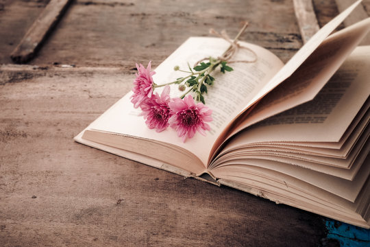 Vintage novel books with bouquet of flowers on old wood background - concept of nostalgic and remembrance in spring vintage background